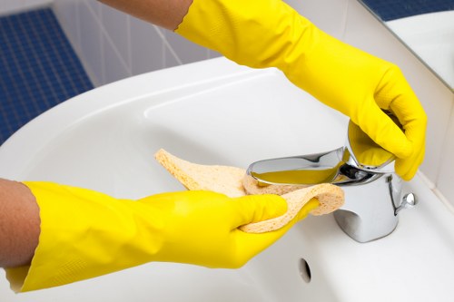 A local commercial cleaner working in a Roehampton workspace with desks and meeting rooms